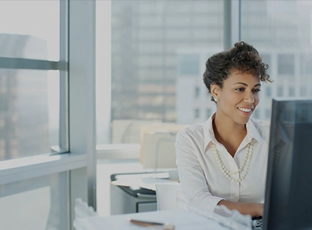 A woman sitting at her desk in front of a computer.